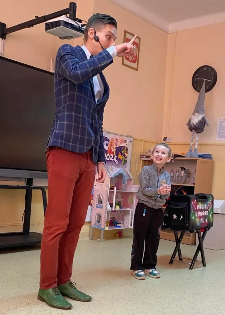 Chłopiec pomaga magikowi podczas pokazu iluzji dla dzieci